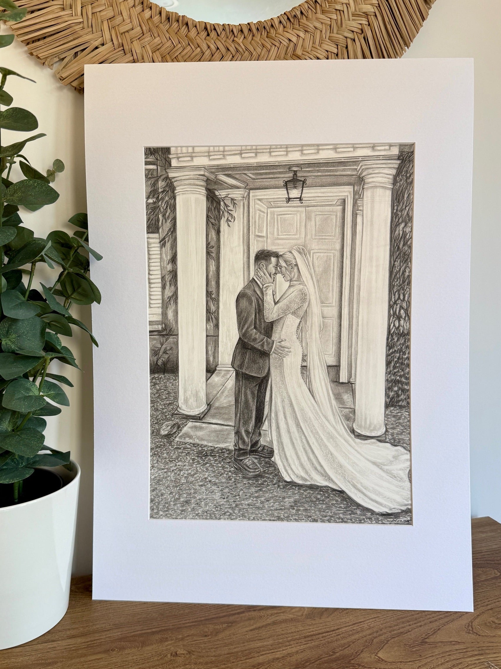 Graphite wedding portrait of a couple beneath a venue arch